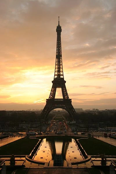 Parigi Versailles e Castelli della Loira. Si vede la Tour Eiffel al tramonto con colori tendenti al giallo, rosa e arancio.