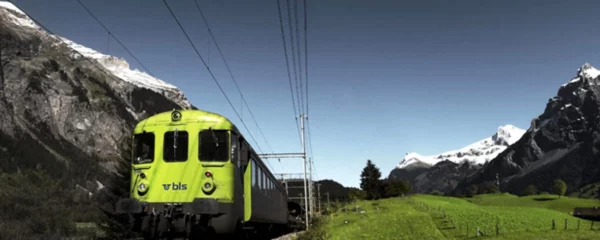 trenino verde delle alpi in viaggio nel mezzo delle montagne e circondato dal verde dei prati, che si dirige verso la festa del vino a Spiez e crociera sul lago di Thun