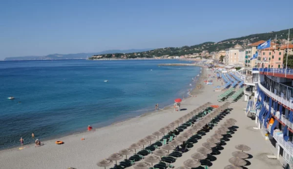 La spiaggia di Varazze in Liguria con il suo mare azzurro e la vista di uno stabilimento balnerare con ombrelloni e ristoranti, che dall'inizio della primavera si riempiono di turisti.