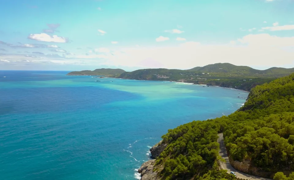 Isola di Minorca, vista dall'alto con mare cristallino e colline verdi che si increspano nel mare, con paesaggio che sembra dipinto Soggiorno baleari minorca